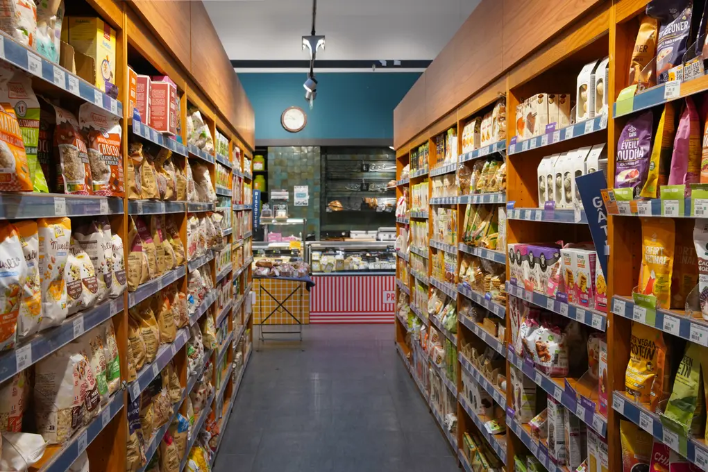 Pour agrandir sa capacité de stock en surface de vente, le magasin utilise des casquettes au-dessus des gondoles d'épicerie.